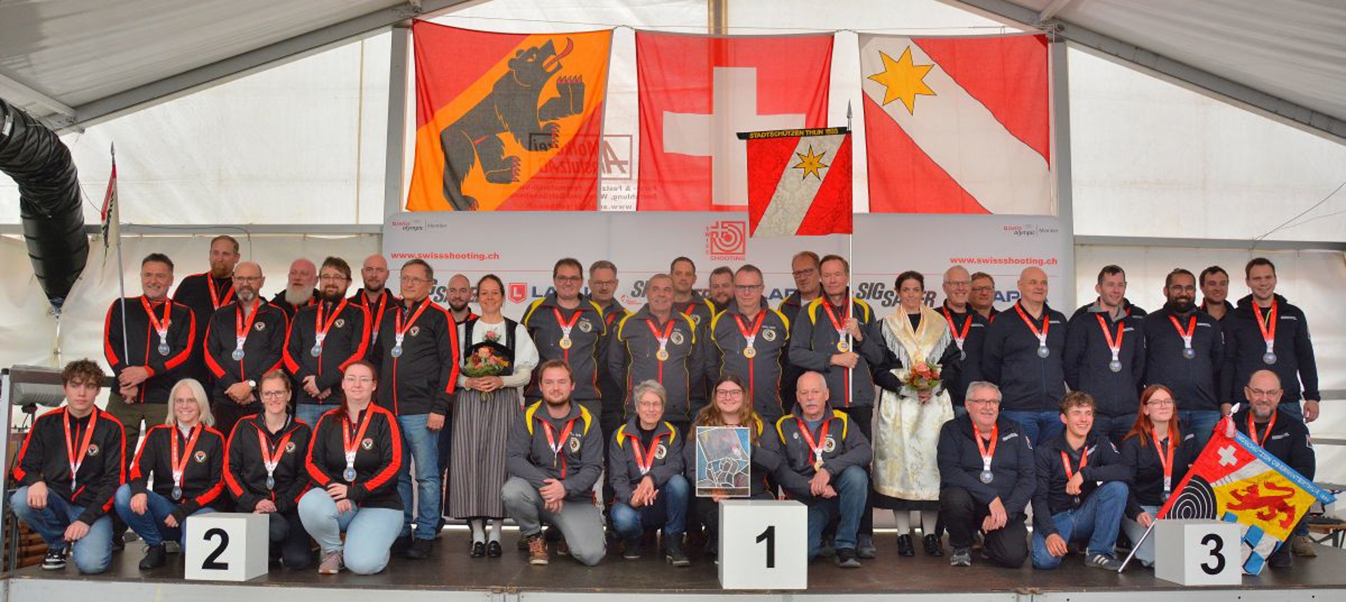 Podest NLA Sport (v.l.): 2. Aarau Schützengesellschaft; 1. Thun Stadtschützen; 3. Oberwinterthur Standschützen, mit den Ehrendamen Iris Bhend-Wenger und Stefanie Koller-Ritz.
