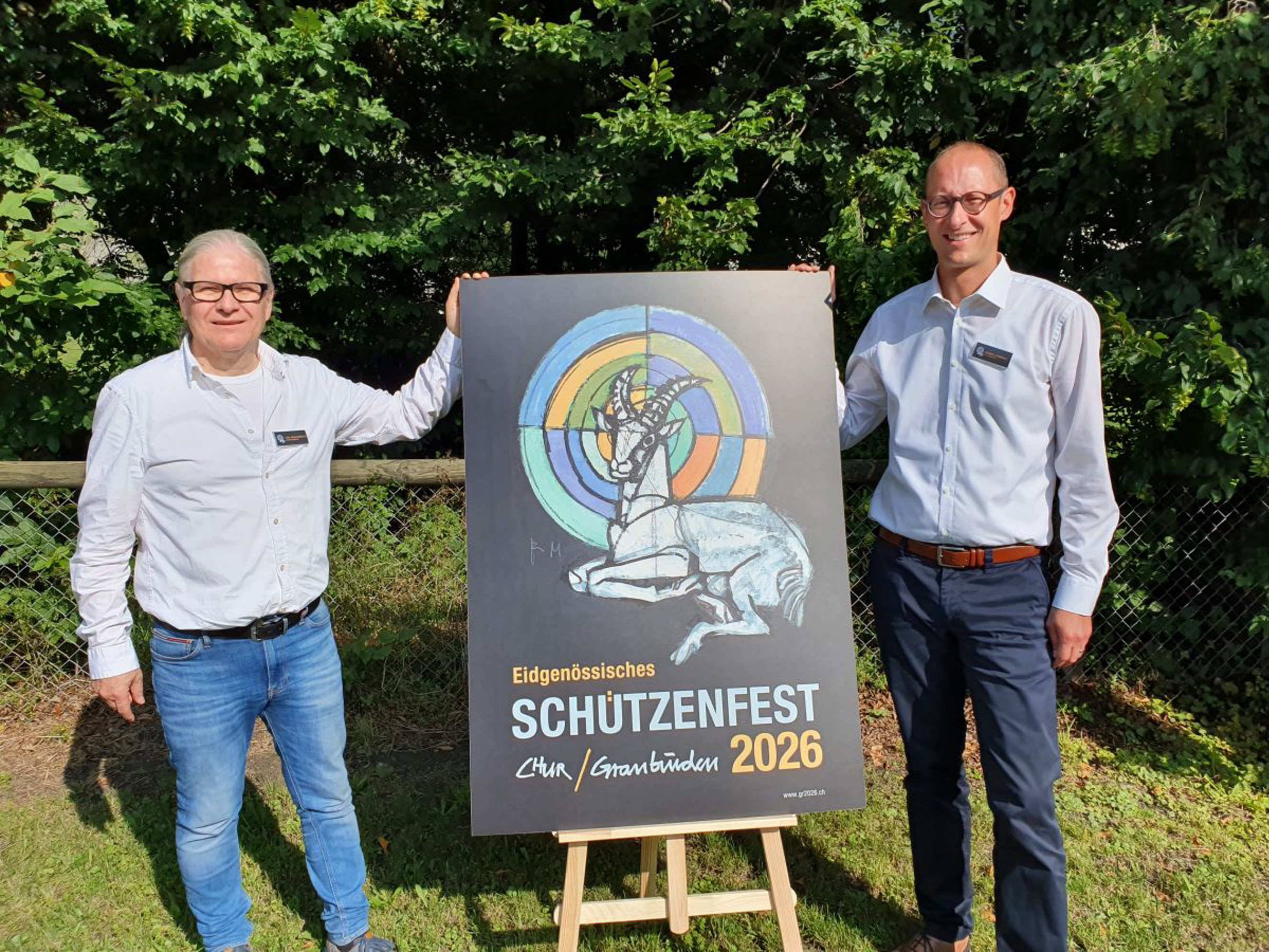 Carl Frischknecht und Martin Candinas präsentieren das Plakat vom ESF Chur 2026 (v.l.).