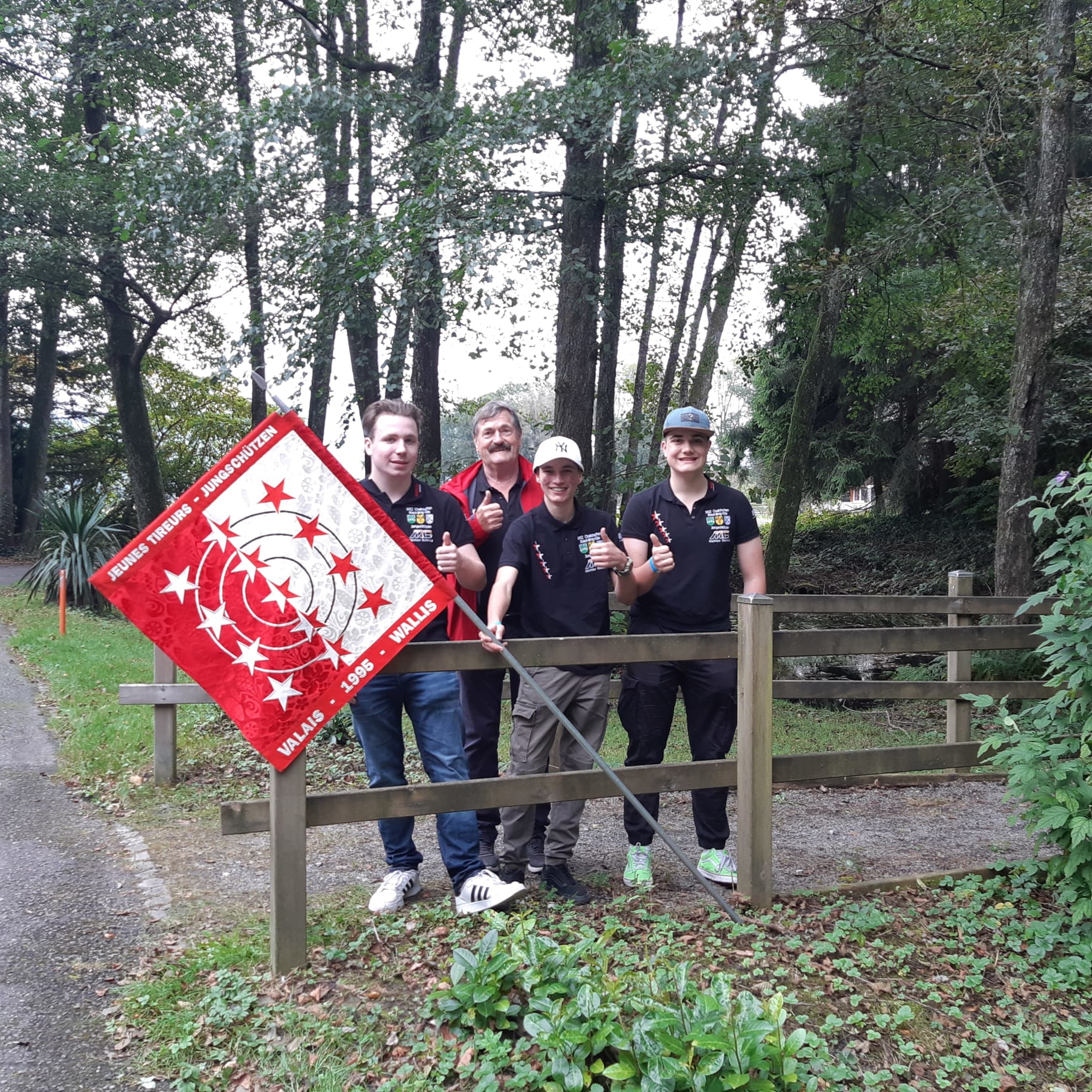 Toni Imfeld,  Betreuer Konrad Gabriel, Tagessieger Fabrizio Walpen und Nicola Willisch mit der Jungschützen-Kantonalfahne des siegreichen Wallis (v.l.).