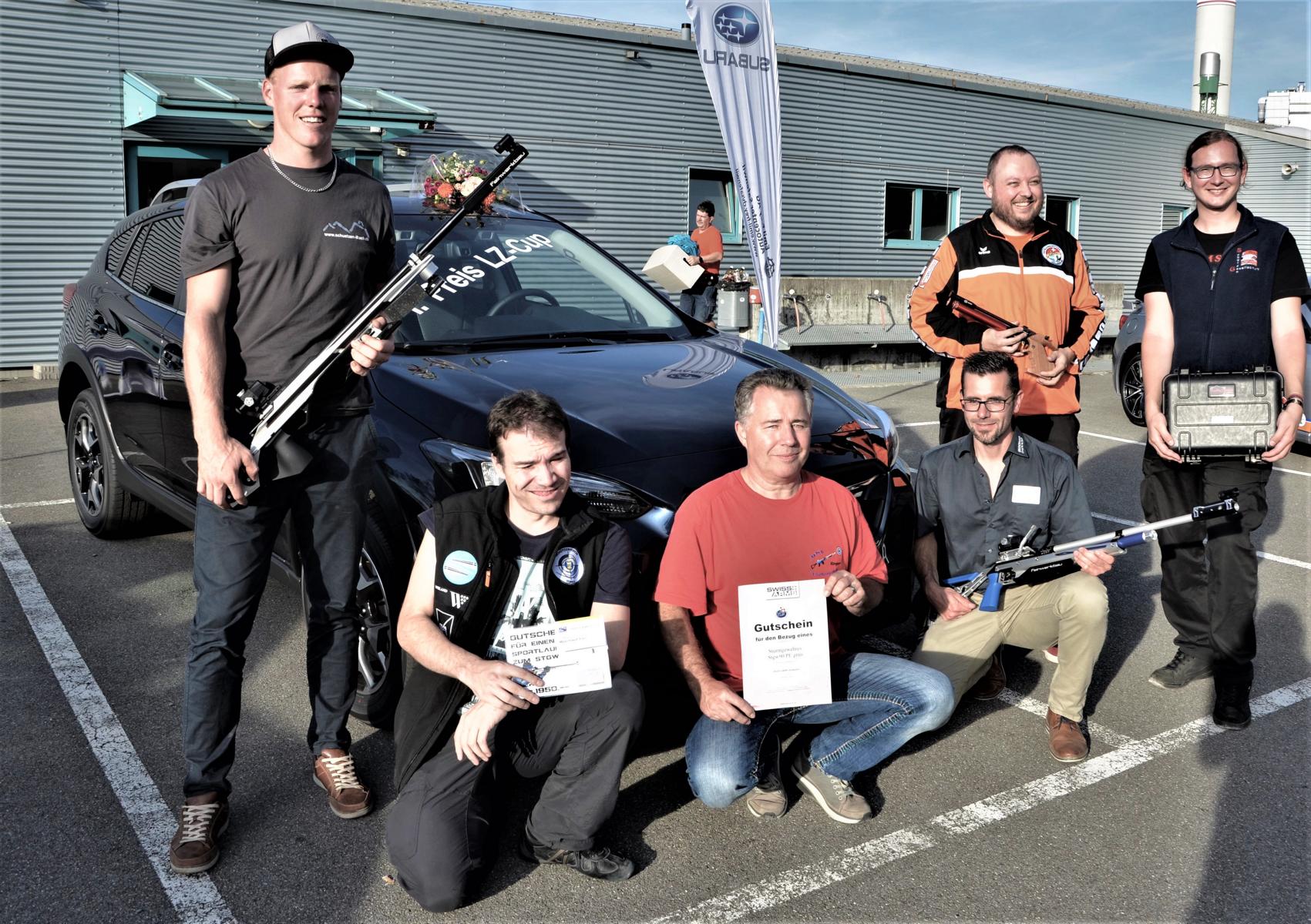 Die sechs Sieger auf einen Blick. Im Hintergrund der Hauptpreis, ein Personenwagen.