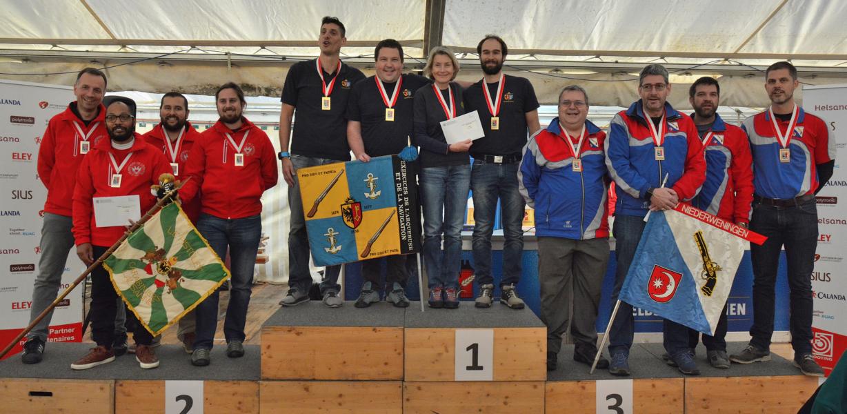 Das Podest: 2. Lausanne Carabiniers mit Michael Witschi, Gérald Hippias, Alvaro Garcia; 1. Genève Arquebuse mit Steve Demierre, Sylvain Rosset, Corine Serra-Tosio, Julien Hisler; 3. Niederweningen mit Renato Kissling, René Kurmann, Thomas Huber, Thomas Huber